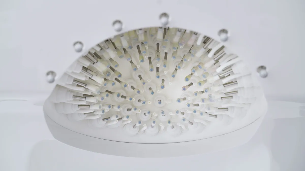 View directly up into a white dome lined with concentric rings of small white transducer modules with metal centres.